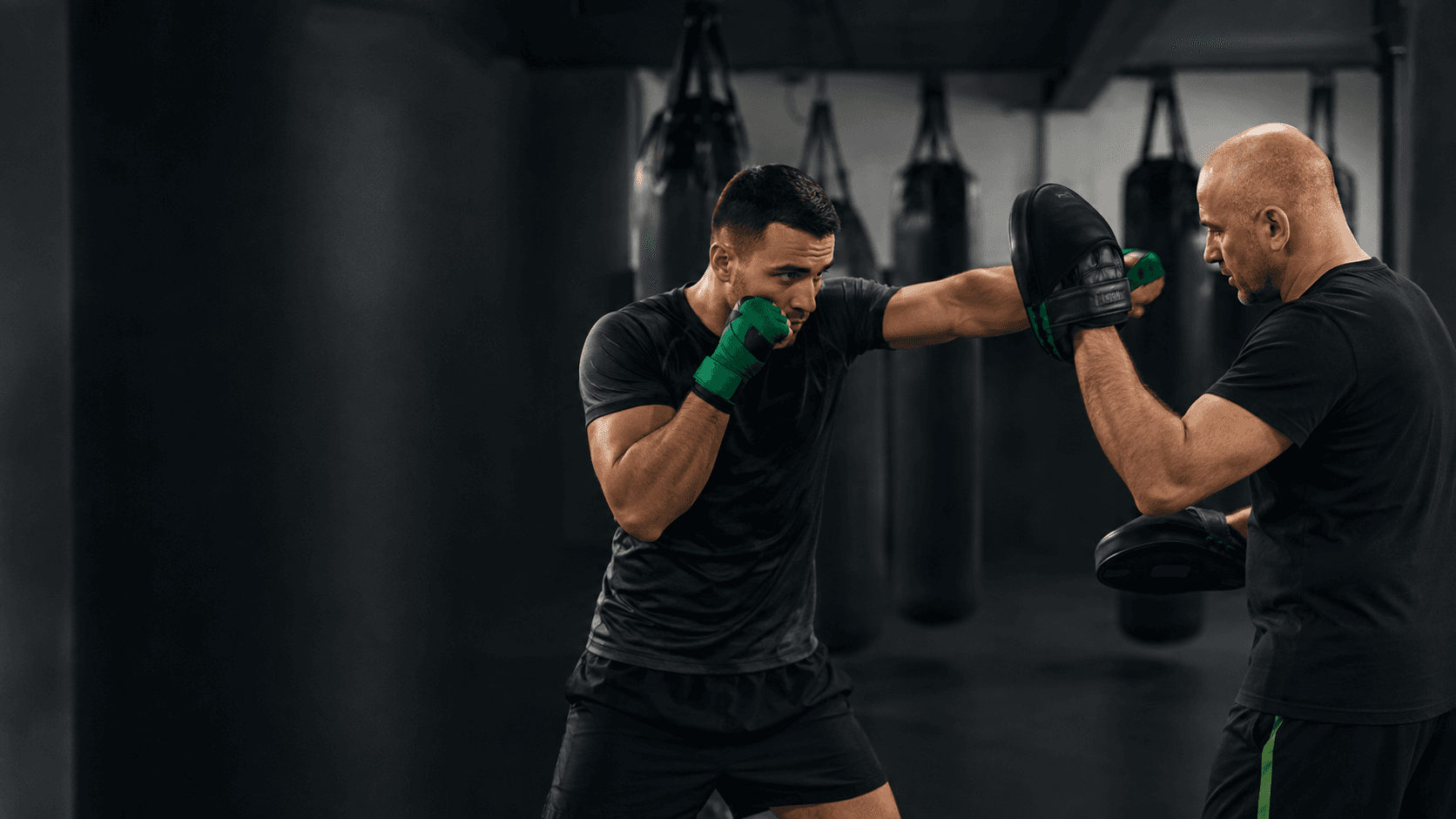 Entrenador personal de boxeo: técnica, preparación y seguridad Entrenador personal de boxeo trabajando técnica de golpeo con manoplas y protecciones