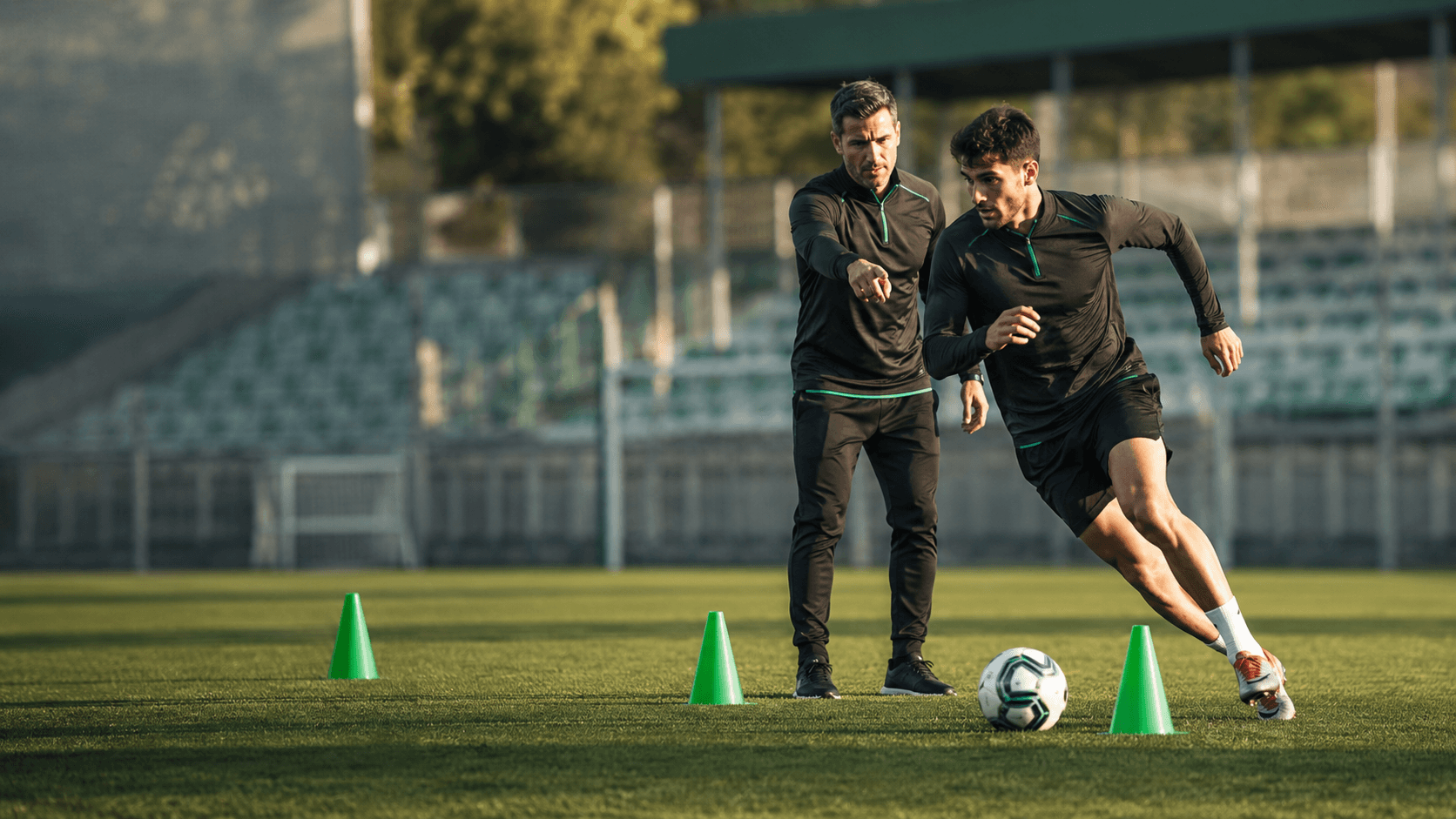 Entrenador personal de fútbol: preparación física individual Preparador físico guiando a un futbolista durante un ejercicio de aceleración y cambio de dirección